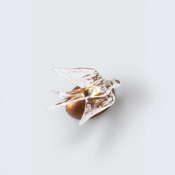 Wall Light with a glass sculpture of a bird on a white background