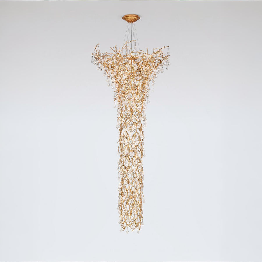 Gold chandelier hanging against a white background