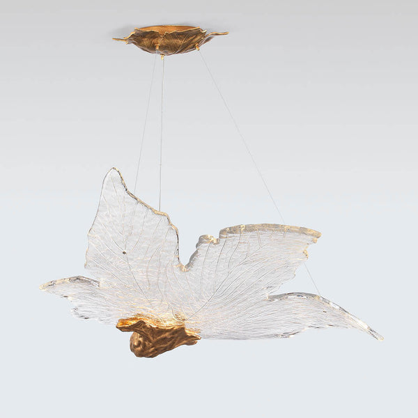 Decorative sculptural hanging light in leaf shape made of brass and glass with gold accents on a white background