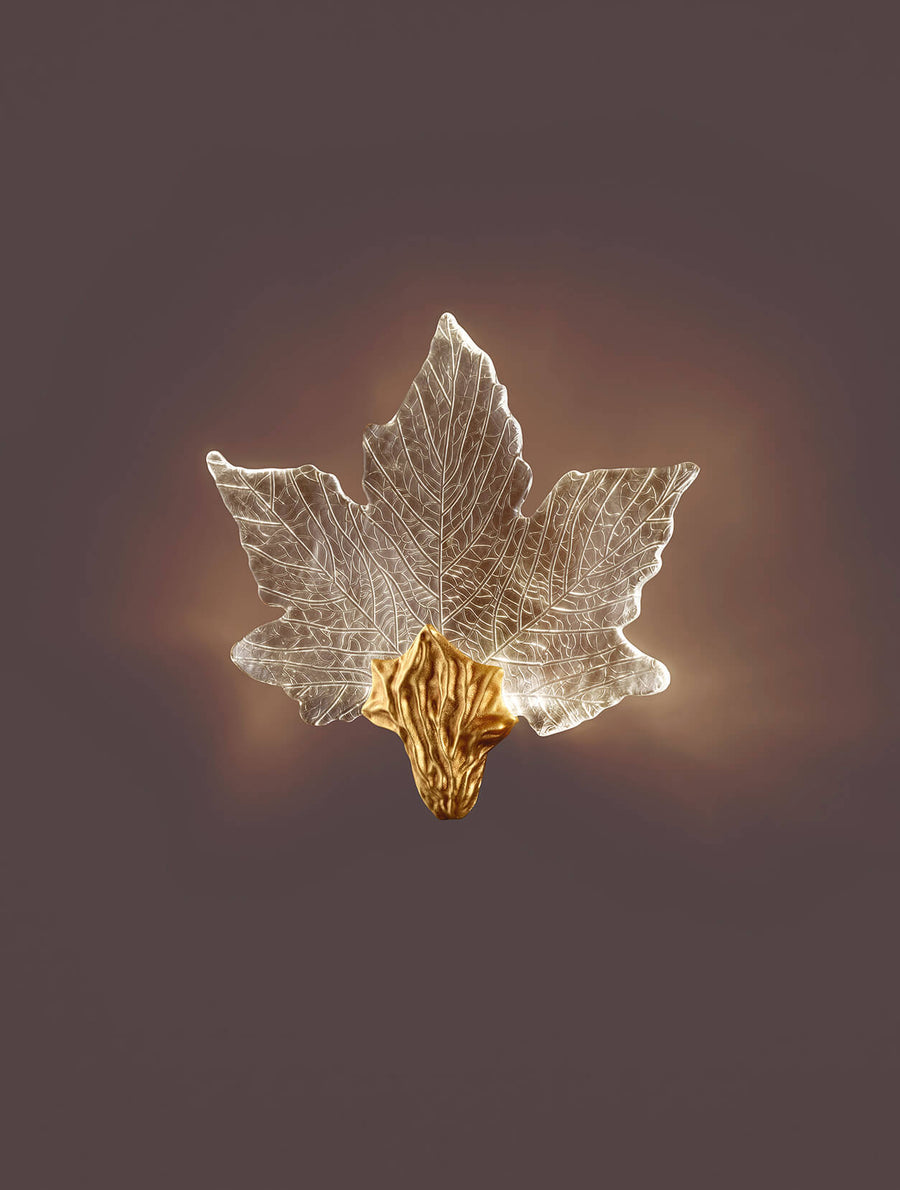 Decorative leaf-shaped wall light with gold base on a dark background