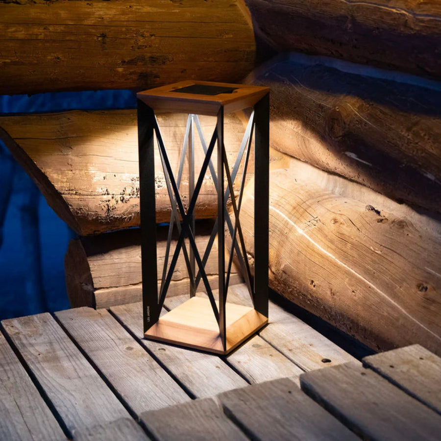 Decorative outdoor lantern on a wooden deck with a rustic background by Les Jardins available at Spacio retail stores in Mumbai & Kolkata. 