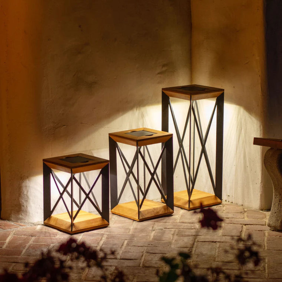 Set of three wooden outdoor lanterns with metal frames against a textured wall  by Les Jardins available at Spacio retail stores in Mumbai & Kolkata. 