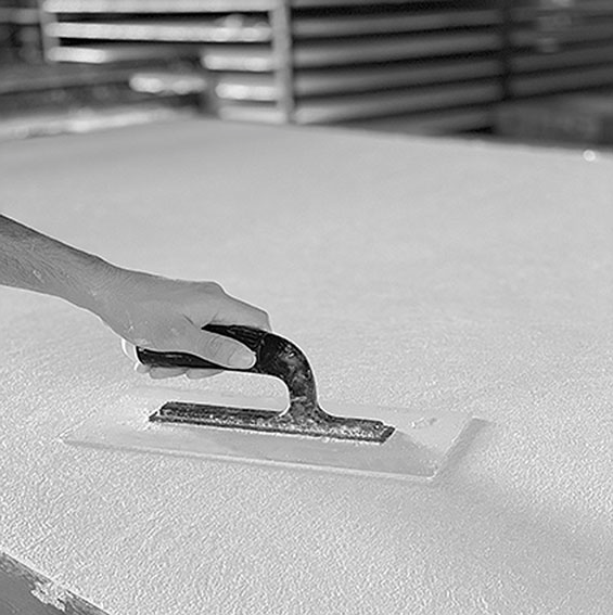 A person is sanding a sheet of white foam, creating a handmade Affreschi 3D Wall 3D02 panel for interior design trends.