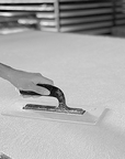 A person is hand sanding a sheet of Affreschi Classic Art AC 100301 foam to create tailored walls.