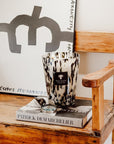 A wooden bench with a book and a Baobab Black Pearls Candle Max 24 MAX24PB on it.
