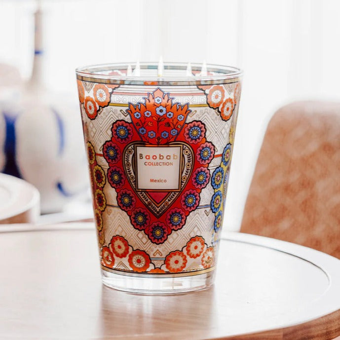 A Baobab Mexico Candle MAX16MEX scented candle is sitting on a table next to a lamp.