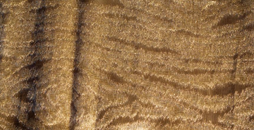 A close up of a brown leather surface featuring a delicate LCD Metal Fabric Moire Collection pattern by LCD Textiles.