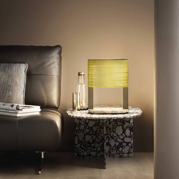 A living room with a brown couch and a yellow lamp featuring a stunning Masiero Ebe Table Lamp design.