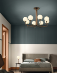 A bedroom with blue walls and a bed featuring the Masiero Tee Chandelier for luxury lighting from Masiero.