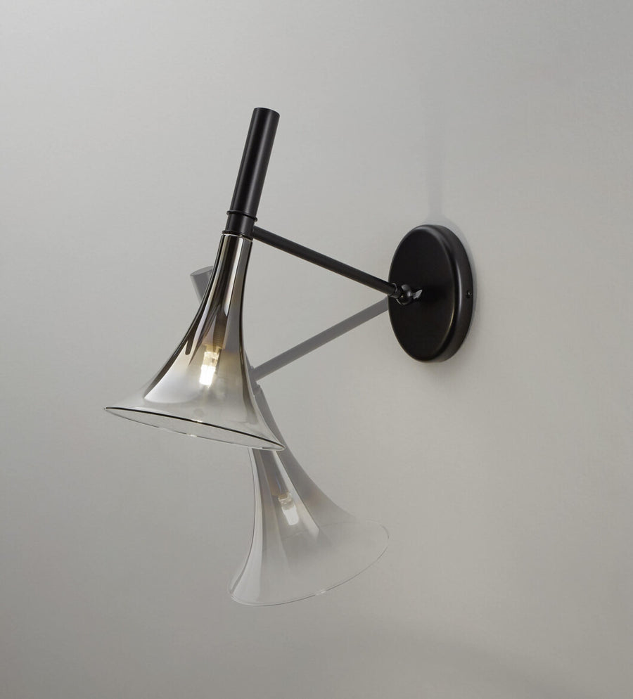 Baffo Collection by Italamp with conical design, titanium finish glass, and matching metal accents, showcasing Italian craftsmanship and elegance. A black and platinum finish baffo wall lamp showing the movement of adjusted