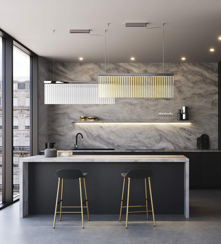 Discover the Carmen collection by Italamp – Italian Murano glass lighting in clear, smoke, and teak finishes. Elegant designs for luxurious interiors. A rectangular suspension of 2 pcs in teak and clear finish over a kitchen pantry counter in a luxury interior