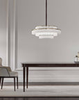 Charles Collection suspension lamp by Italamp featuring gold nickel finish, satin glass elements, and leather accents, epitomising Italian luxury lighting design. A Charles chandelier above a wooden dining table in a modern luxury interior