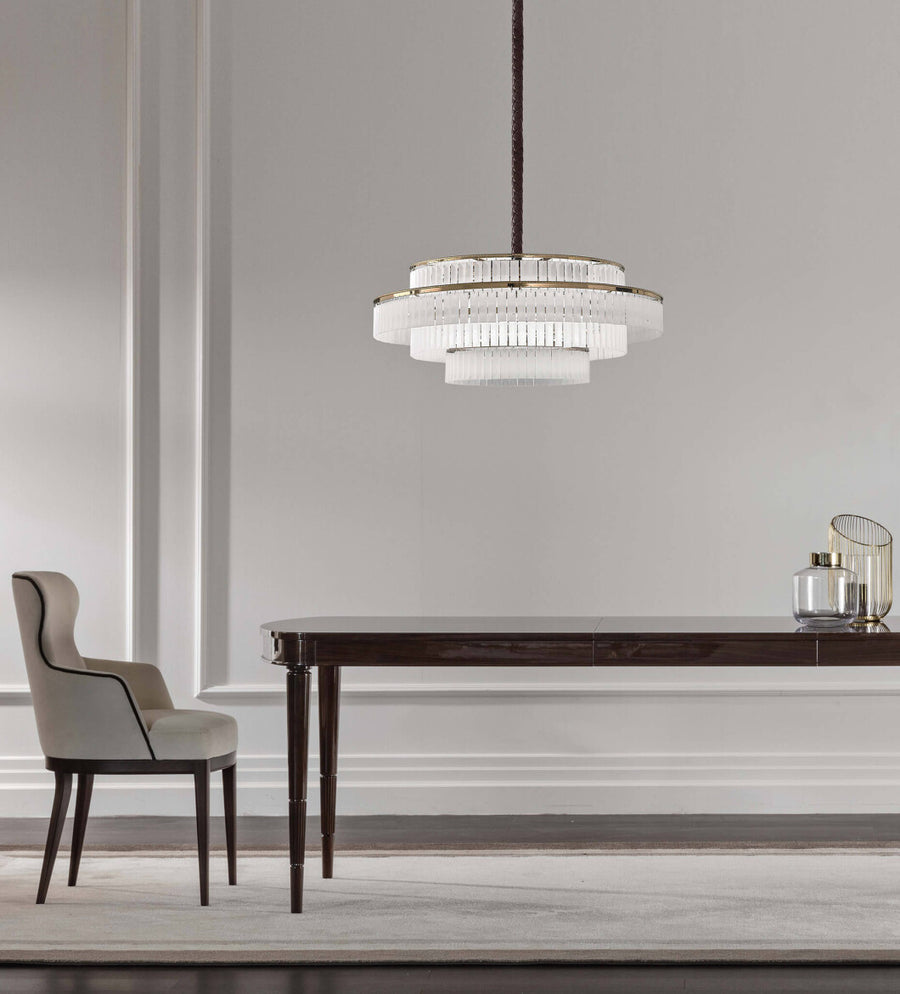 Charles Collection suspension lamp by Italamp featuring gold nickel finish, satin glass elements, and leather accents, epitomising Italian luxury lighting design. A Charles chandelier above a wooden dining table in a modern luxury interior