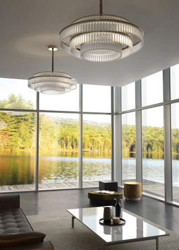 Charles Collection suspension lamp by Italamp featuring gold nickel finish, satin glass elements, and leather accents, epitomising Italian luxury lighting design. A pair of Charles chandelier in a luxury outhouse with windows next to a water body above a centre table in a living room