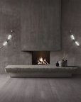 Colier collection by Italamp, featuring modular blown glass elements in vibrant colours and shapes, designed by Marc Sadler to create magical lighting effects. A pair of wall sconce on a grey theme interiors on the 2 sides of a fireplace and some art object on a grey stone ledge. 