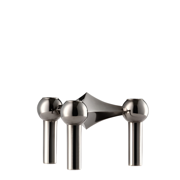 A polished stainless steel candle holder set with three spherical knobs and cylindrical stems, shown on a solid white background from Stoff Nagel, available at Spacio in India. 