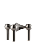 A polished stainless steel candle holder set with three spherical knobs and cylindrical stems, shown on a solid white background from Stoff Nagel, available at Spacio in India. 