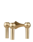 A modern three-spoke brass candle holder with spherical finials and cylindrical legs, shown on a plain white background from Stoff Nagel, available at Spacio in India. 