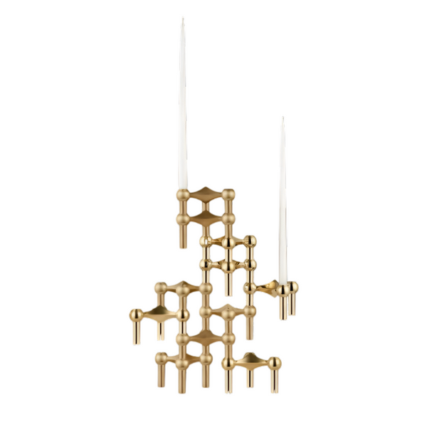 A modern gold-toned metal candelabra with an abstract geometric design, holding two white taper candles, isolated on a white background.
