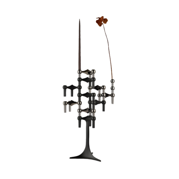 A modern abstract metal candle stand sculpture on a white background, featuring a dark bronze base, multiple branching arms with spherical accents, and a single long stem ending in a small flower-like form.