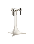 A polished silver metal candle holder stand with three vertical candle sleeves and a wide, sculptural base, shown on a solid white background.