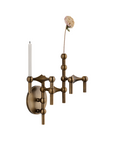 An ornate wall-mounted candle-style sconce in an antique brass finish, featuring a circular backplate, three branching arms with bead-like accents, a single white candle, and a tall dried flower stem extending upward, shown against a plain white background.