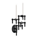 A black wall-mounted double candle holder with two white taper candles, shown against a plain white background.