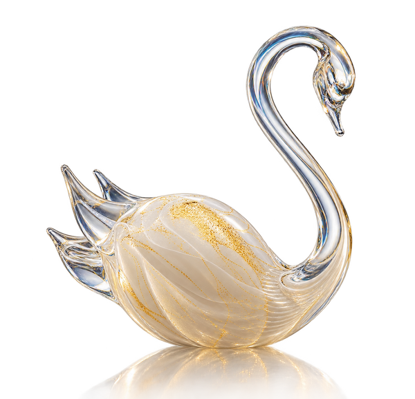 A decorative crystal swan figurine with a curved neck, featuring a milky white body with gold glitter accents and a clear glass beak and tail, set against a plain white background with a soft reflection below.