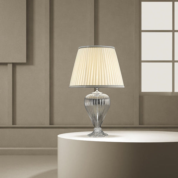 A Venetian glass table lamp with cream colour fabric shade on a round coffee table in a modern contemporary luxury interiors