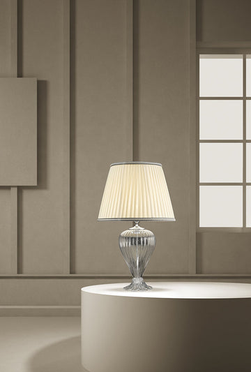 A Venetian glass table lamp with cream colour fabric shade on a round coffee table in a modern contemporary luxury interiors