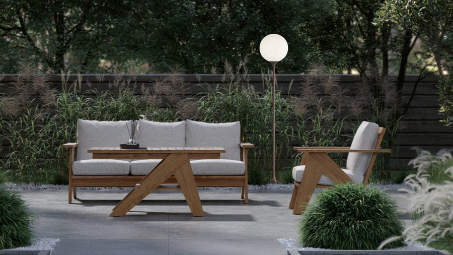 Outdoor furniture set with wooden table and chairs in a garden setting and a floor lamp. 