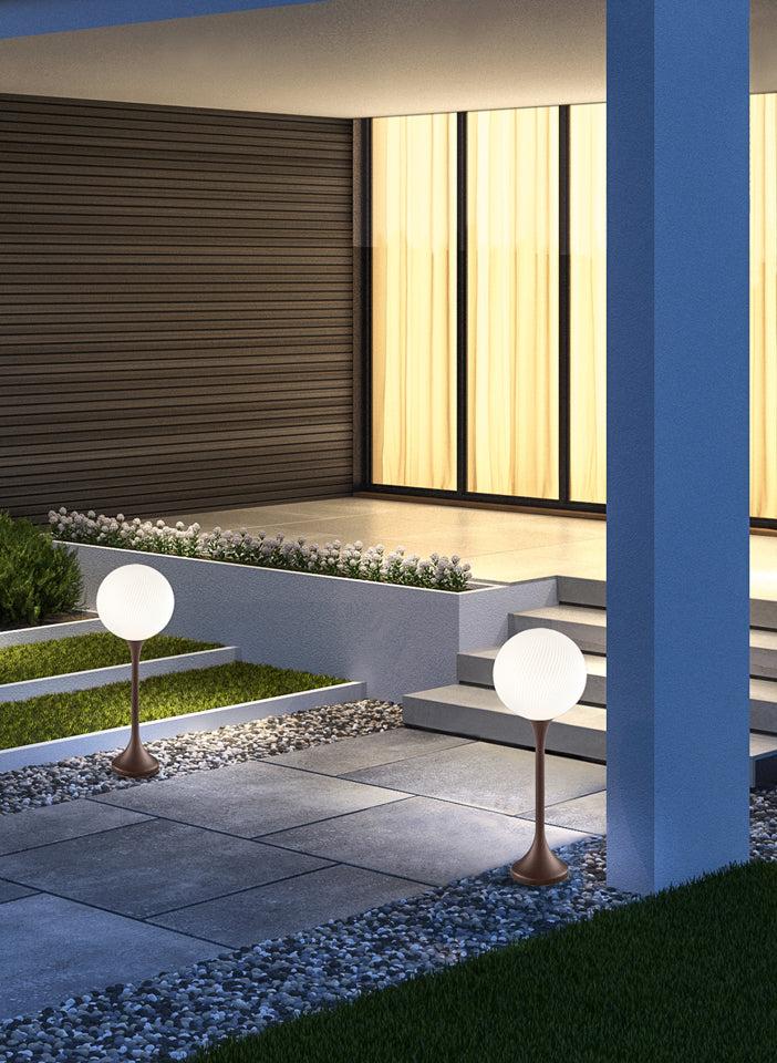 Modern outdoor setting with two spherical garden lights on a stone path.