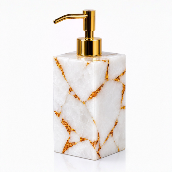 White quartz soap dispenser with gold accents on a white background