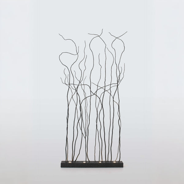 Decorative metal floor lamp with branch-like patterns on a light gray background