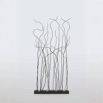 Decorative metal floor lamp with branch-like patterns on a light gray background