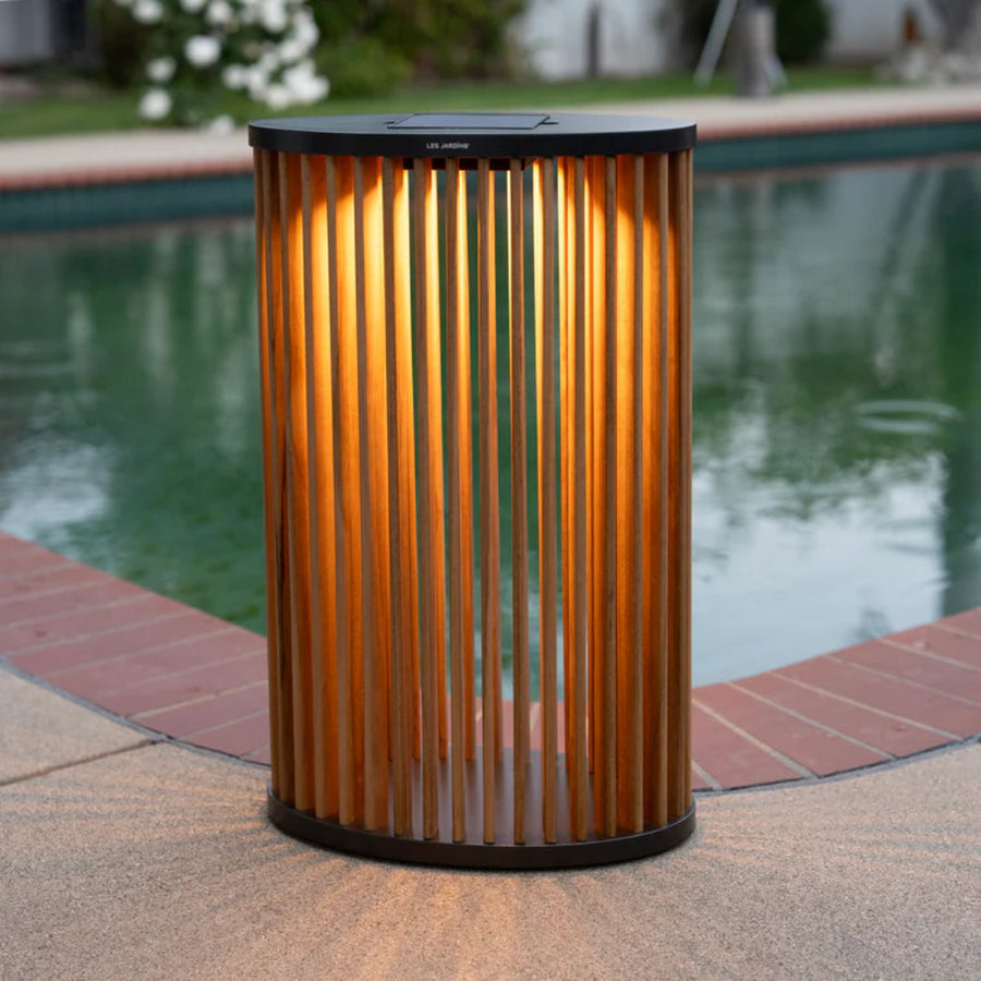Cylindrical outdoor solar light lantern with corrugated design near a pool by Les Jardins available at Spacio retail stores in Mumbai & Kolkata. 