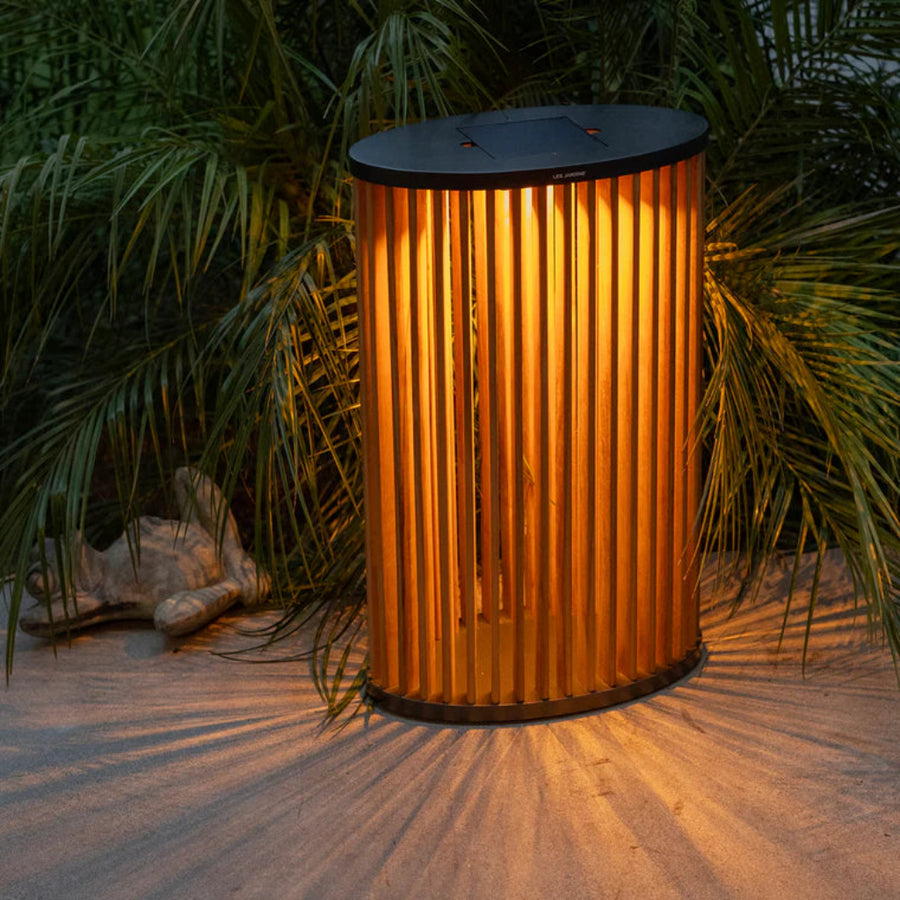 Decorative outdoor light fixture on a sandy surface with plants in the background by Les Jardins available at Spacio retail stores in Mumbai & Kolkata. 