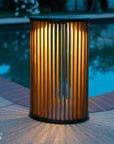 Decorative outdoor solar lamp with ribbed design by a poolside by Les Jardins available at Spacio retail stores in Mumbai & Kolkata. 