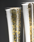 Two elegant clear glass sculptural vase with a metallic gold foil leaf pattern, shown against a dark gray background.