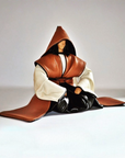 A stylized kneeling samurai wearing a brown hooded robe with white sleeves and black boots, posed against a plain light gray studio background.