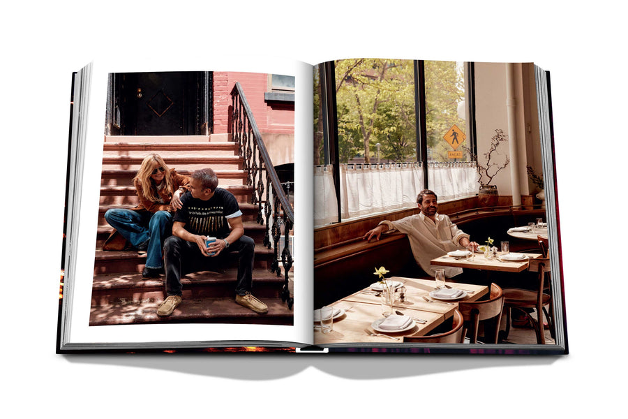 Assouline New York Chic coffee table book displaying photos of Creative director Demet Müftüoglu-Eseli with director Alphan Eseli on the stairs & seating in a restaurant on white back ground available at Spacio India for luxury home decor accessories collection of Travel Coffee Table Books.