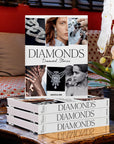 Assouline Diamonds: Diamonds Stories coffee table book on a wood coffe table beside a flower vase in modern interior available at Spacio India for luxury home decor collection of Jewellery Coffee Table Books.