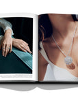 Assouline Diamonds: Diamonds Stories coffee table book displaying image of De Beers Dewdrops stacking rings in white & rose gold and De Beers' snowflake designed diamond pendant on a white back ground available at Spacio India for luxury home decor collection of Jewellery Coffee Table Books.