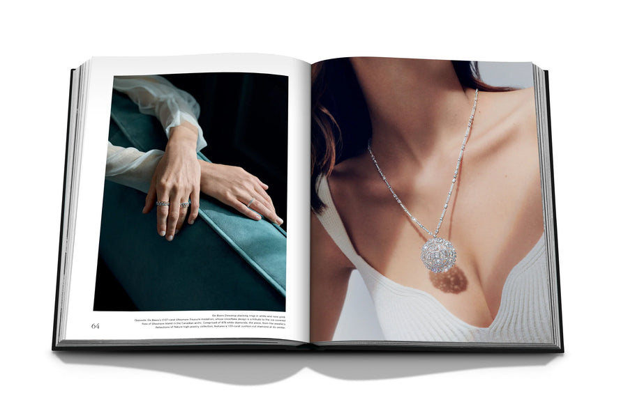 Assouline Diamonds: Diamonds Stories coffee table book displaying image of De Beers Dewdrops stacking rings in white & rose gold and De Beers' snowflake designed diamond pendant on a white back ground available at Spacio India for luxury home decor collection of Jewellery Coffee Table Books.