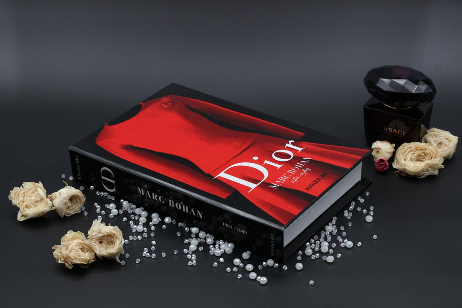 Assouline Dior by Marc Bohan coffee table book on a grey back ground decorated with diamonds, pearls & white roses available at Spacio India for luxury home decor collection of Fashion Coffee Table Books.
