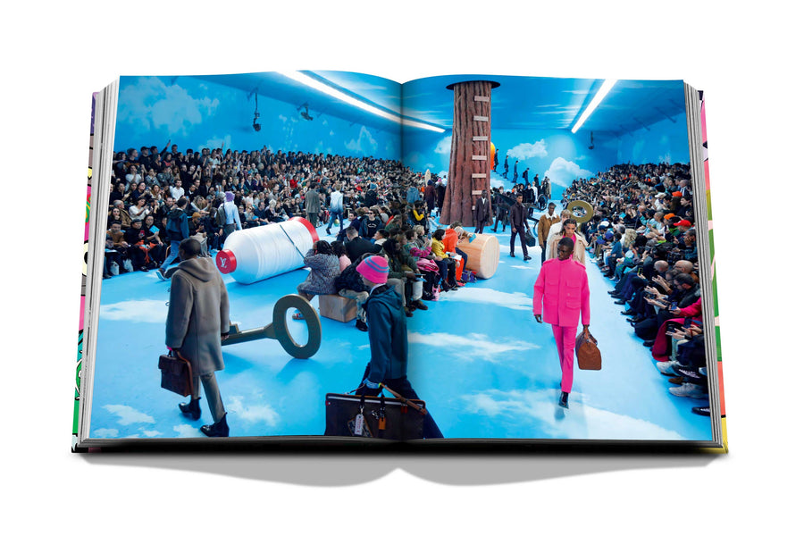 Assouline Louis Vuitton: Virgil Abloh Classic Cartoon Cover coffee table book displaying photo of The men’s collection by US designer Virgil Abloh for Louis Vuitton fashion house during the Paris Fashion Week, January 2020 on a white back ground available at Spacio India for luxury home decor accessories collection of Fashion Coffee Table Books.