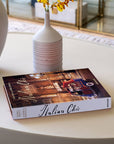 Assouline Italian Chic coffee table book on a round table with vases with beige themed interior available at Spacio India for luxury home decor accessories collection of Travel Coffee Table Books.