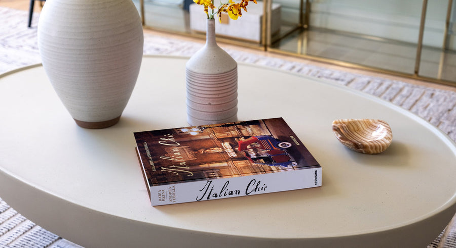 Assouline Italian Chic coffee table book on a round table with vases with beige themed interior available at Spacio India for luxury home decor accessories collection of Travel Coffee Table Books.