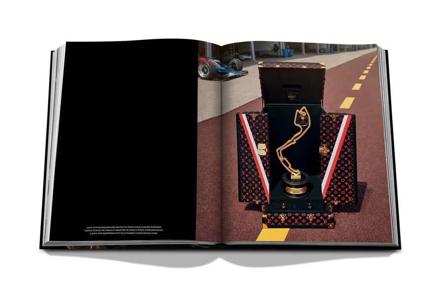 Assouline Louis Vuitton: Trophy Trunks coffee table book displaying image of F1 Monaco Trophy Louis Vuitton on a white back ground available at Spacio India for luxury home decor accessories collection of Fashion Coffee Table Books.