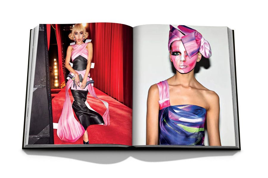 Assouline Moschino coffee table book displaying photos of Model Gigi Hadid wearing a baby doll dress & a model painted her face for fashion runway on a white back ground available at Spacio India for luxury home decor accessories collection of Fashion Coffee Table Books.
